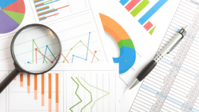 Magnifying glass over printed analytics charts and graphs