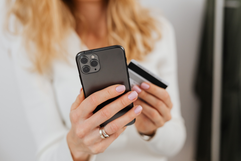 Shopper holding a phone and a credit card while completing a mobile purchase