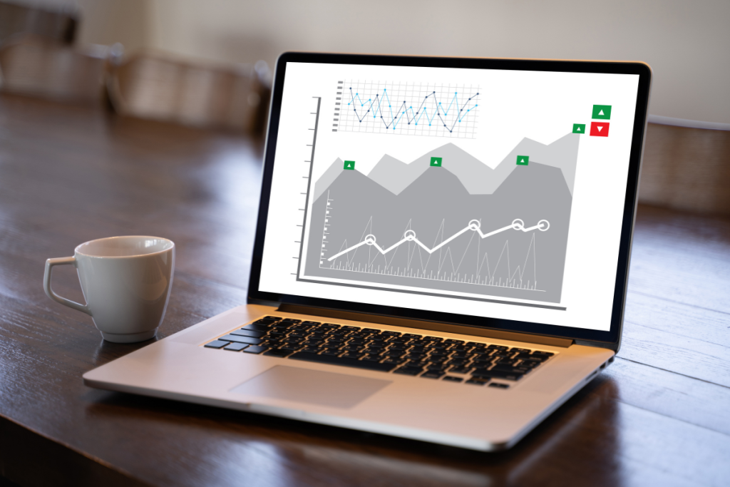 Laptop on a desk showing website performance charts and trend indicators