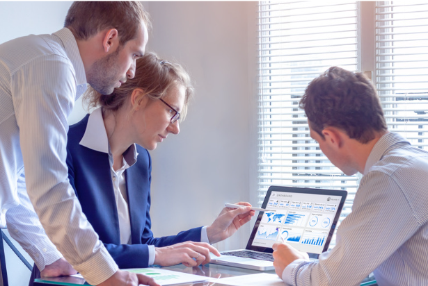 Marketing team reviewing website analytics data together on a laptop